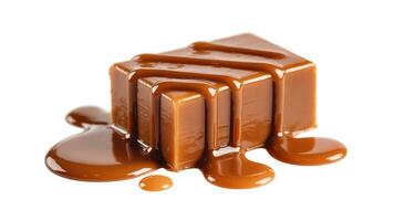 Close up of a caramel candy square with caramel sauce dripping on a white background photo