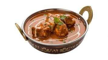 Close up of butter chicken in a metal bowl with cream and cilantro garnish isolated photo