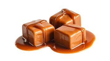A delectable trio of caramel candies glistening with sweet sauce on a pristine white surface photo
