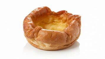 A single yorkshire pudding with a golden brown crust on a bright white background in studio light photo