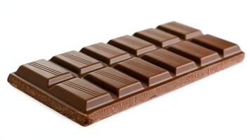 A close up shot of a milk chocolate bar with rectangular pieces on a white background photo