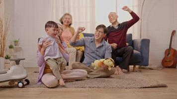 A toddler joyfully walks across the room for the first time as family members celebrate with laughter and excitement. The warm atmosphere highlights their love and support during this milestone. video