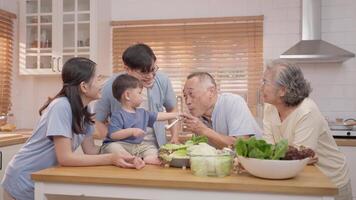 A lively family gathering unfolds in a bright kitchen as kids and adults share laughter while preparing a meal. Ingredients are spread across the counter, symbolizing togetherness. video