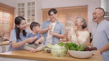 A joyful family engages in cooking activities in a sunny kitchen. They share laughter and love as they prepare fresh ingredients, creating a warm atmosphere of togetherness. video