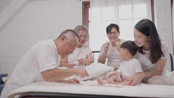 Several family members enjoy a delightful time together in a comfortable room, sharing laughter and engaging with a young child, creating joyful memories. video