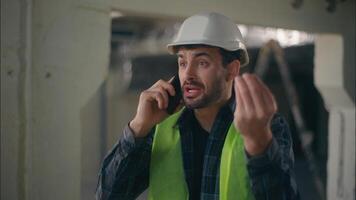 Annoyed Caucasian man contractor holding mobile phone speaking remote call conflict in construction builder foreman arguing furious guy technician building industry working problem upset male argument photo