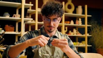 A man is diligently working on creating a piece of pottery in a pottery studio photo