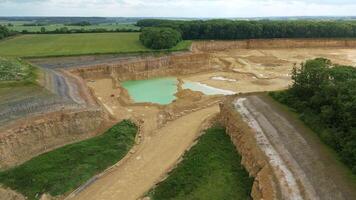 Mining pit quarry producing aggregates and rare earth minerals in England UK sunny day video