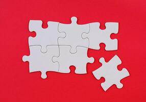 White Puzzle Pieces on Red Background. Missing Piece Concept. Stock photo. photo