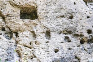Cells in the face of the rock, used by monks of the cave monastery photo