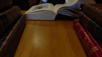 Man leafing through old books at a table video