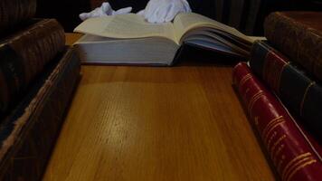 Man leafing through old books at a table 02 video