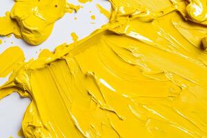 A close up of a yellow paint splattered on a white surface photo