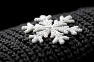 A close up of a knitted snowflake on a black background photo