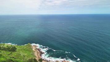Experience breathtaking aerial views of cliffs and vibrant greenery along the picturesque coastal shoreline photo