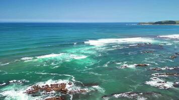 Be amazed by the breathtaking view of a serene coastline with crystal clear turquoise waters and lush greenery photo