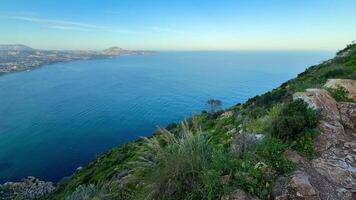 A breathtaking landscape that features lush greenery along with a stunning panoramic view of the ocean photo