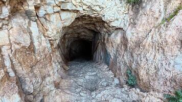 Venture into a mysterious tunnel with rocky walls leading to an intriguing dark passage waiting to be explored photo