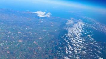 A breathtaking and captivating perspective of Earth showcasing both clouds and land from a notably high altitude photo