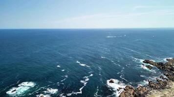 The breathtaking ocean view from a high cliff beautifully showcases the waves rolling in under blue skies photo