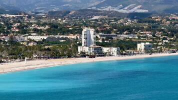 An aerial view shows a serene beach with clear turquoise waters and beautiful beachfront properties photo
