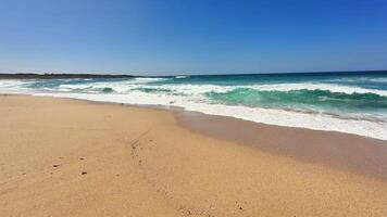 A peaceful and tranquil beach scene showcasing soft, gentle waves lapping against a bright, sunny shore photo