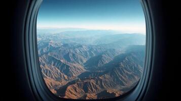 Magnificent view from an airplane window showcasing mountain ranges under a clear blue sky afar photo