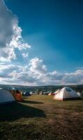 Camping under blue skies summer adventure in the wilderness surrounded by nature and majestic mountains exploring vast landscape photo