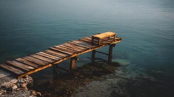 Wooden pier and bench on the calm ocean water providing a tranquil coastal scenery and landscape photo
