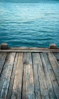 Seascape from rustic wooden dock reveals serene blue water inviting exploration and peaceful contemplation against the horizon line photo