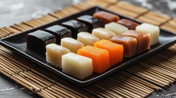 A black plate with various types of japanese sweets photo