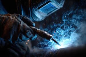 A welder focuses intently on a metal piece, generating bright blue sparks and swirling smoke in a dimly lit workshop during nighttime photo