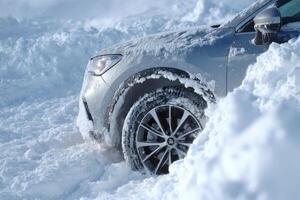 A silver SUV struggles to navigate through deep snow, indicating difficult winter driving conditions and heavy snowfall accumulation photo