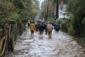 People navigate through deep water in a flooded area of their neighborhood following significant rainfall during the fall season photo