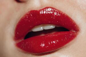 Lips are highlighted with glossy red lipstick, emphasizing a glamorous makeup style. The focus is on the texture and shine photo