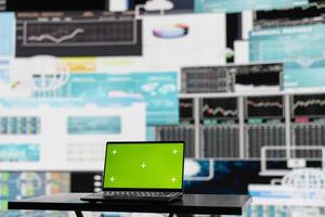 Isolated green screen running on the laptop next to fintech annual trends, ensuring a strategy for corporate success. Showcasing reports and infographics performance metrics to improve activity. photo