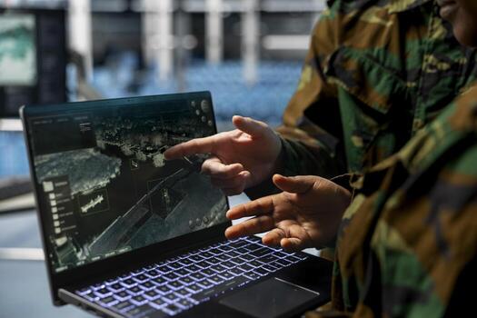 Close up of army experts in data center analyzing infrared surveillance feed on tactical interface. Military units operating real time satellite reconnaissance from secure server room photo