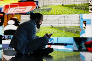 Stressed individual obsessively overuses his mobile phone social platforms, illustrating the mental health crisis driven by addiction and excessive information. Cyberbullying and manipulation. photo