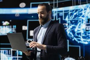 Entrepreneur uses laptop to review artificial intelligence brain system on dashboards, using high tech data visualization for coding, analytics and machine learning. Strategic development. photo