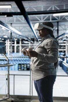 Server room engineer visualizing AI model outputs using VR gear, managing infrastructure systems. Data center worker using virtual reality technology, running artificial intelligence software tests photo