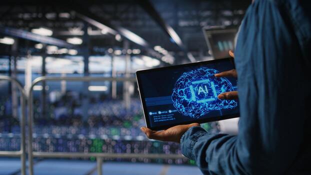 Close up of server farm admin using tablet to do infrastructure AI machine learning automatization. Data center software developer doing maintenance using artificial intelligence, photo