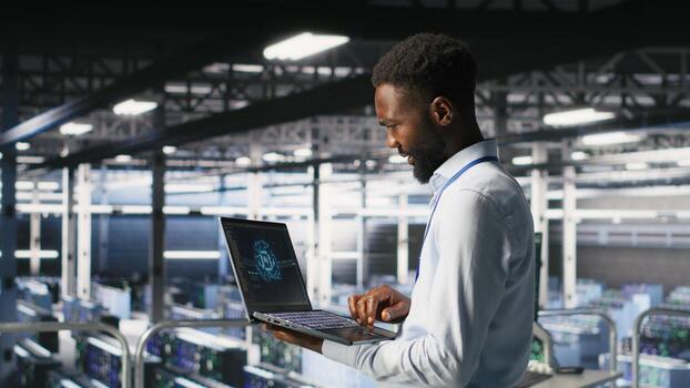 Programmer and colleague in data center reviewing AI LLM visualizations on laptop. IT teamworking coworkers analyze neural network performance outputs to ensure stable infrastructure operations photo