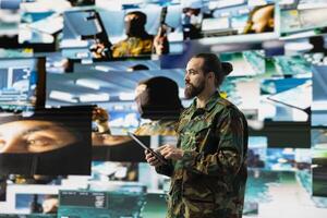 Military personnel monitoring drone and satellite imagery to gather data, finding enemy position helpful for war planning. Supporting national defense mission and secure global operations. photo