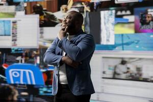 Smiling african american influencer being connected on vibrant digital interfaces and visualizations, representing mobile content creation, global reach and social network web experiences. photo