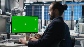 Solar panels inspection group review data on pc next to green screen, finding errors during a process audit and helping optimize renewable energy operations. Photovoltaics factory. Camera B. photo