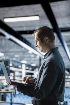 ingeniero en datos centrar gerente software actualizaciones para sistema estabilidad utilizando ordenador portátil. empleado en servidor granja optimizando actuación, configurando infraestructura utilizando solicitud en cuaderno foto