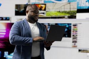 Young black person showcasing visual representation of online connection, immersed in web platforms and apps. Mobile technology surrounded by social network icons in a digital space. photo
