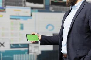 General director with a chroma key display reviewing performance metrics, finance graphs and strategy tools to guide a new investment and decision making. Long term business growth. photo