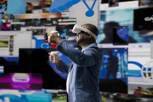 African American guy navigating social networks with high tech VR glasses, visualizing trends for digital engagement platforms through mobile apps and streaming. Digitalization. photo