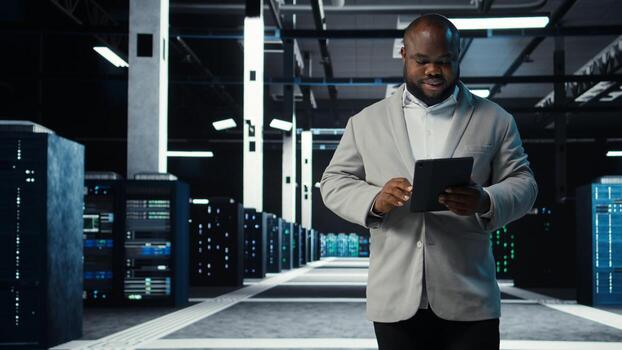 sistema administrador caminando en datos centrar analizando infraestructura actuación salidas en tableta. servidor granja empleado haciendo trabajo tareas, sintonia FINA supercomputadoras configuraciones, cámara un foto